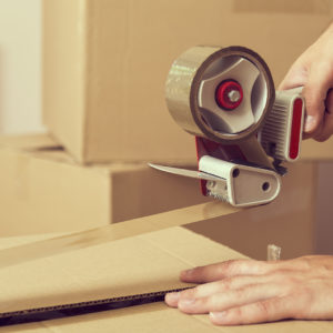 Image of a person taping a box shut