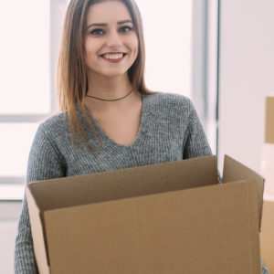 Image of a young woman holding a box